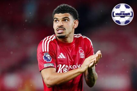 شعار نادي نوتنغهام فورست على خلفية ملعب كرة قدم أوروبي