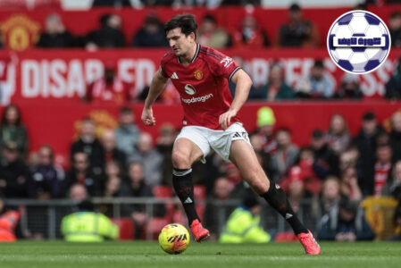 شعار نادي مانشستر يونايتد مقابل شعار نادي أستون فيلا على خلفية ملعب أولد ترافورد